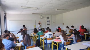 Des élèves suivent un cours tandis qu'une enseignante se tient près du tableau blanc a la Cité scolaire Albert Camus à Mourenx, Nouvelle-Aquitaine, France, 1 Septembre 2026. Plusieurs élèves écrivent à leur bureau tandis que le tableau blanc presente des informations manuscrites.