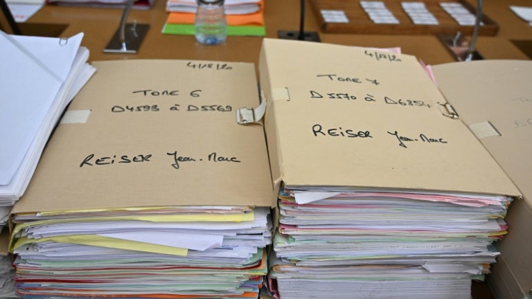 Les dossiers concernant Jean-Marc Reiser sur une table de la cour d'assise du Haut-Rhin, au premier jour de son procès en appel pour le meurtre de Sophie Le Tan, le 20 juin 2023 à Colmar