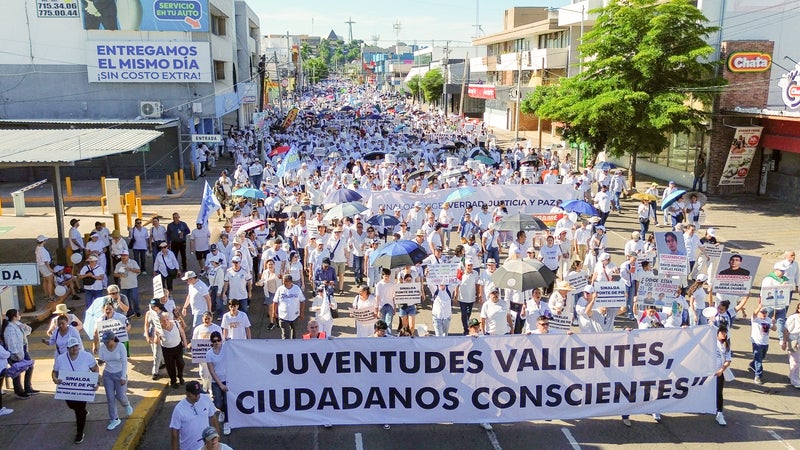 Des manifestants brandissent des banderoles lors de la Marche pour la paix à Culiacán, dans l'État de Sinaloa, au Mexique, le 13 septembre 2026.