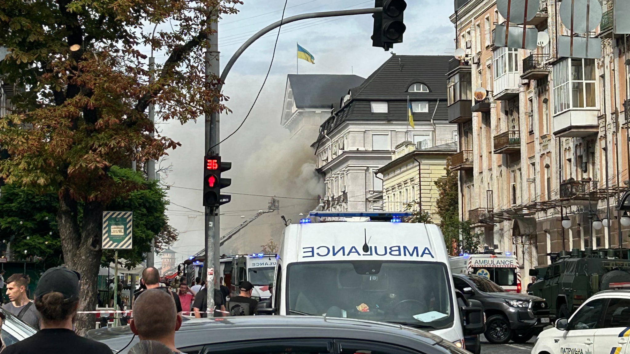 Des badauds observent les secouristes ukrainiens s'affairer à éteindre un incendie au siège du Service de sécurité d'Ukraine (SBU) à la suite d'une attaque aérienne survenue à Kiev le 4 septembre 2026.